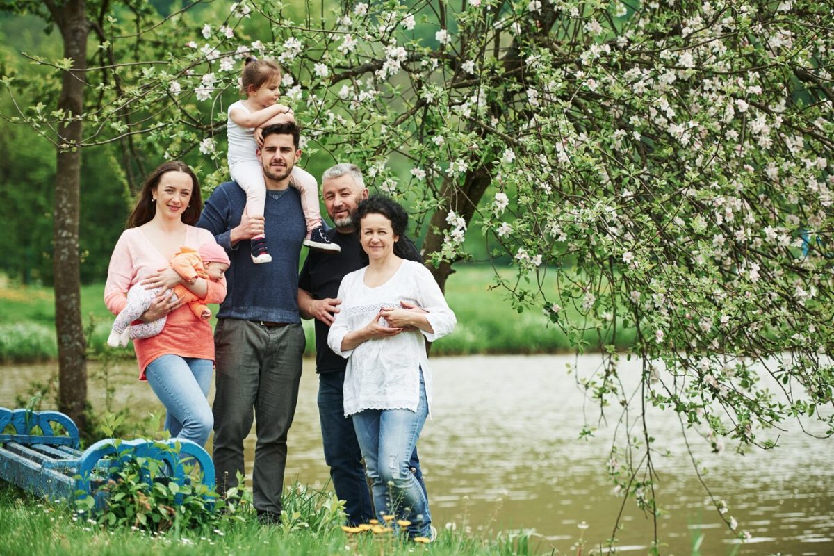 family-photo-full-length-portrait-cheerful-people-standing-outdoors-together-near-lake_146671-16282